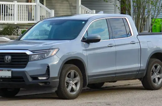 Szary Honda Ridgeline stoi przed domem.