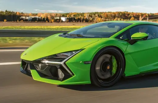 Jaskrawozielony Lamborghini Revuelto pędzi po drodze, ukazując swoje futurystyczne linie i sportowe detale.