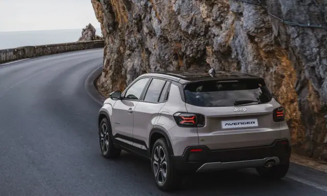 Nowy Jeep Avenger, jeden z najnowszych jeep modele, pokonuje krętą drogę nad morzem, wspinając się po skalistym zboczu.