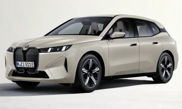 Elegancki, beżowy BMW iX z nowoczesnym grillem i smukłymi światłami.