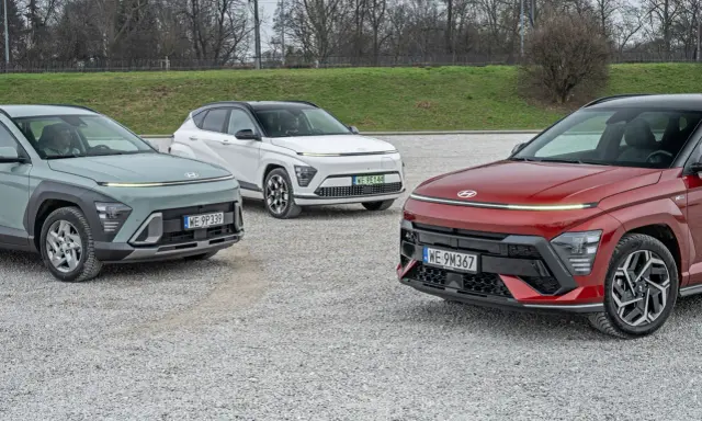 Trzy nowe Hyundai w różnych kolorach: zielony, biały i czerwony, zaparkowane na żwirowym placu.