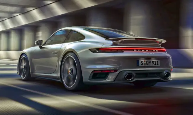 Srebrne Porsche 911 Turbo S pędzi przez tunel. Zastanawiasz się, ile kosztuje Porsche 911?
