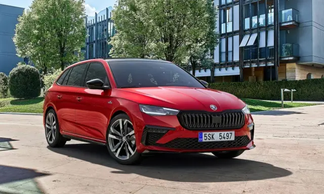 Czerwona Skoda Scala na tle nowoczesnego budynku. Sprawdź atrakcyjną skoda scala cena i wybierz swój wymarzony samochód.