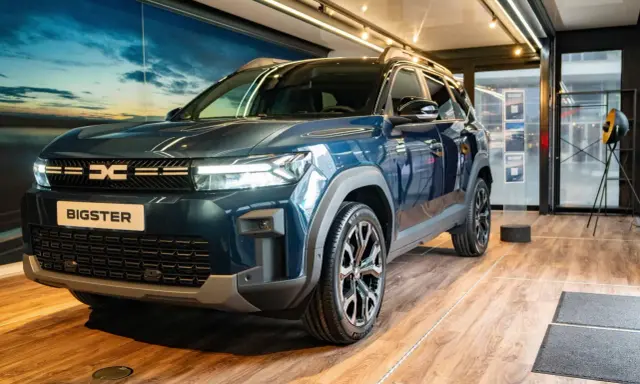 Nowy Dacia Bigster w ciemnoniebieskim kolorze, prezentowany w salonie. Sprawdź jego atrakcyjną dacia bigster cenę!