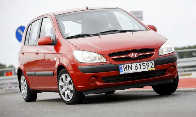 Czerwony Hyundai Getz 1.1 z polskimi tablicami WN 61592 na drodze.