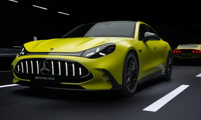 Jaskrawożółty Mercedes-AMG GT 63 z czarnym dachem i felgami, na ciemnym tle z białymi pasami drogowymi.