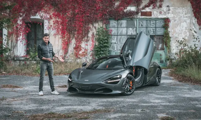 Mężczyzna prezentuje szarego McLarena 720S z otwartymi drzwiami. Zastanawiasz się nad mclaren 720s cena?