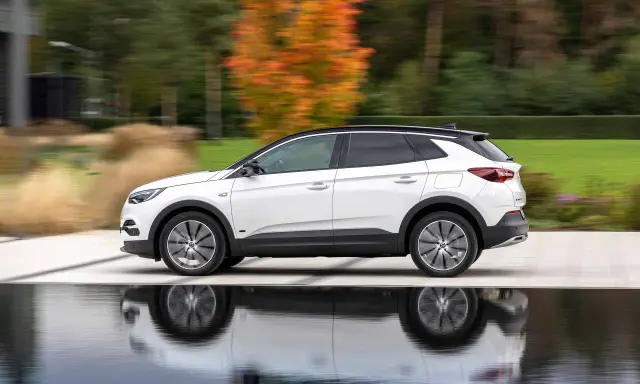 Biały Opel Grandland w ruchu, z refleksami na wodzie. Sprawdź aktualną opel grandland cena i wybierz swój wymarzony SUV.