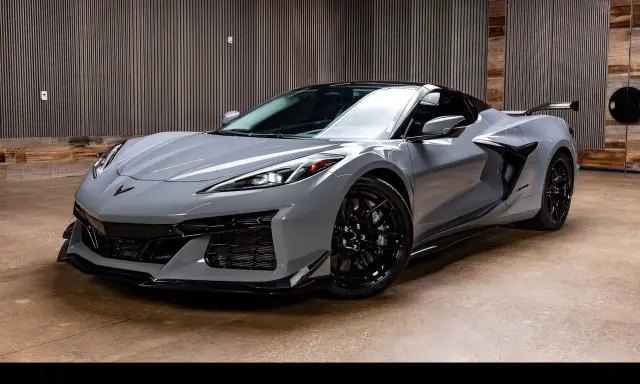 Szary Chevrolet Corvette C8, jeden z najnowszych chevrolet modele, prezentuje się dynamicznie na tle nowoczesnego wnętrza.
