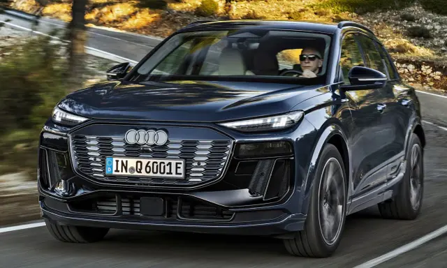 Ciemnogranatowy Audi Q6 e-tron jedzie po krętej drodze. Sprawdź atrakcyjną audi q6 e-tron cenę.