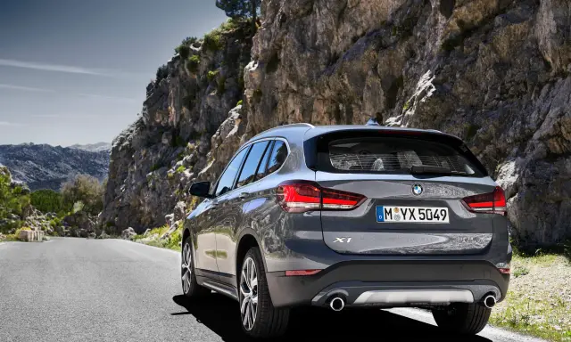 Szary BMW X1 na krętej drodze wśród skał. Sprawdź aktualną bmw x1 cena i wybierz się na przygodę!