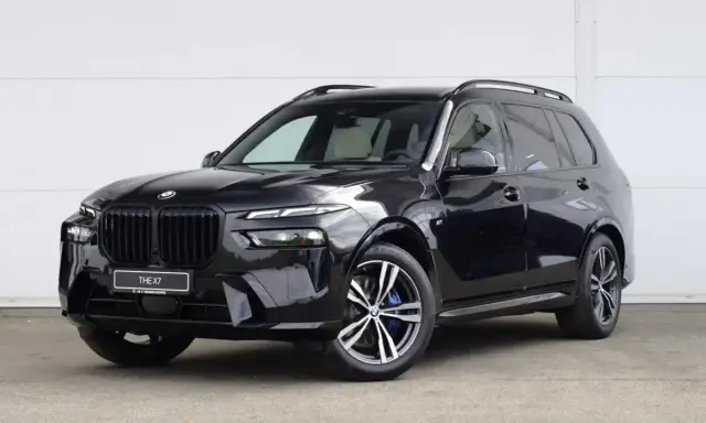 Czarny BMW X7 na tle białej ściany. Sprawdź aktualną bmw x7 cena i dostępne konfiguracje.