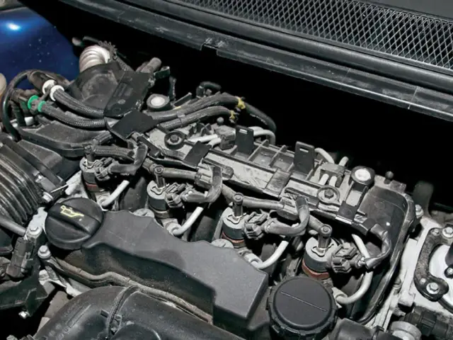 Silnik Volvo V50 1.6 diesel z widocznymi wtryskiwaczami, przewodami i zbiorniczkiem płynu chłodniczego.