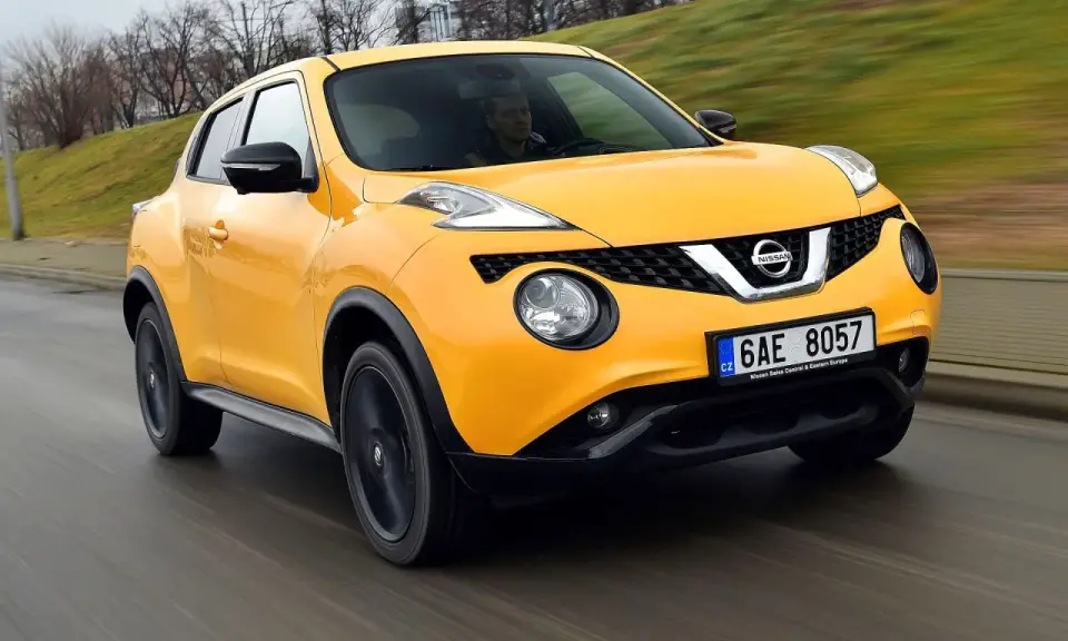 Żółty Nissan Juke 1.6 benzyna w ruchu ulicznym.