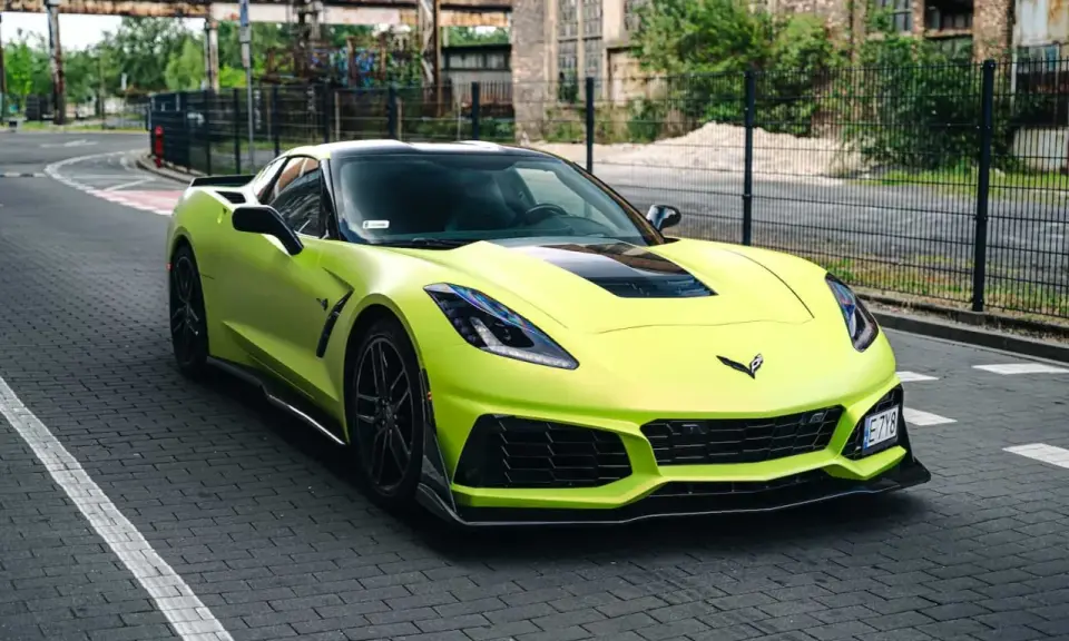 Jasnozielony Chevrolet Corvette C7 na brukowanej drodze. Zastanawiasz się nad corvette c7 cena?