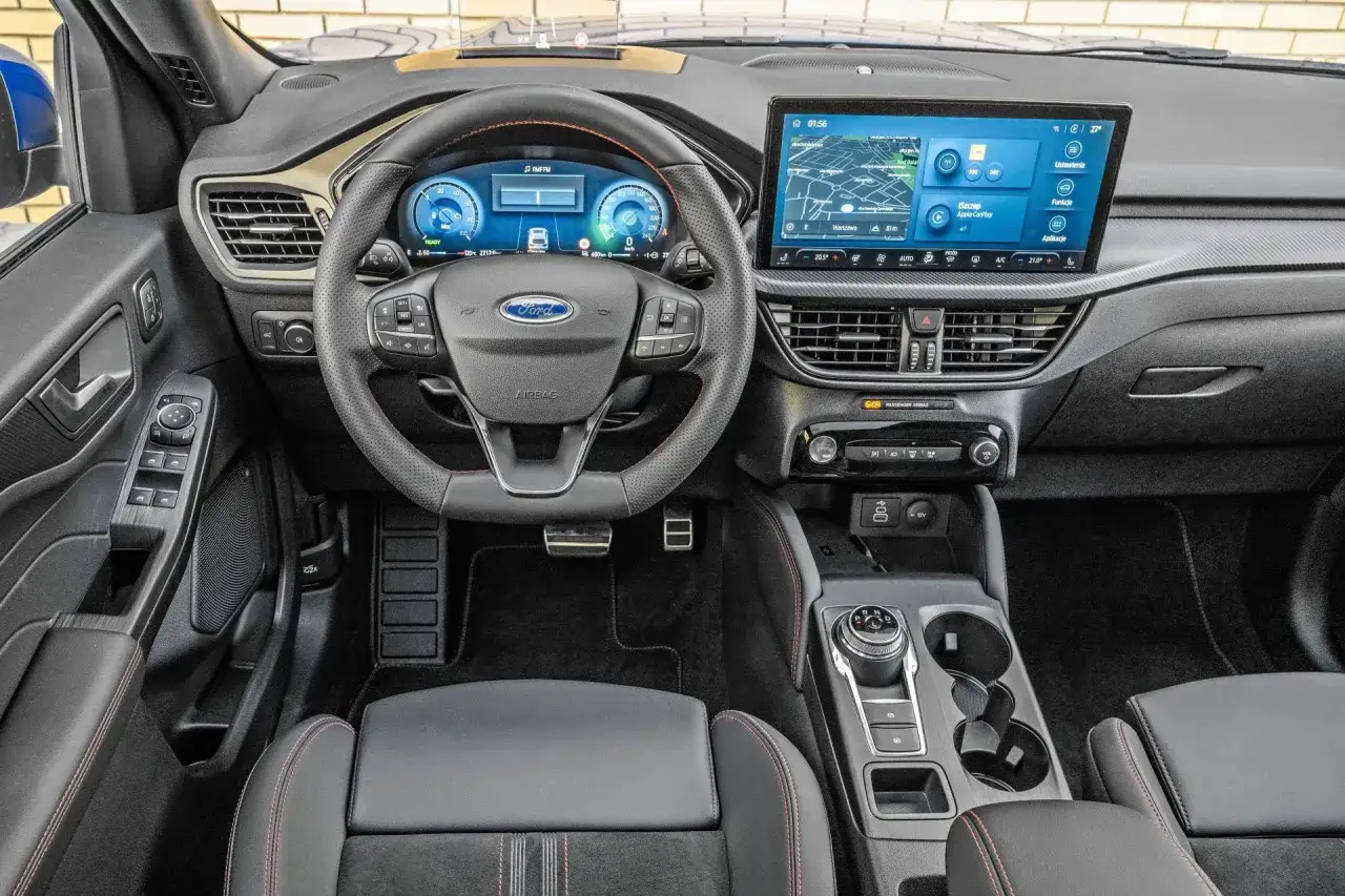 Wnętrze Forda Kuga z nowoczesnym ekranem multimedialnym i cyfrowymi zegarami. Sprawdź aktualną ford kuga cena!