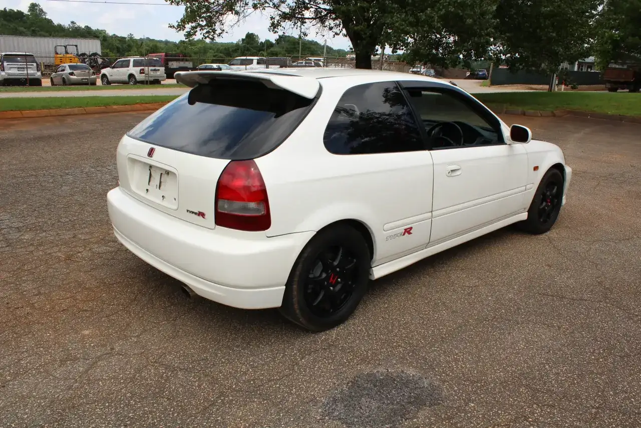 Białe Honda Civic EK9 Type R z czarnymi felgami i spojlerem, gotowe do jazdy.