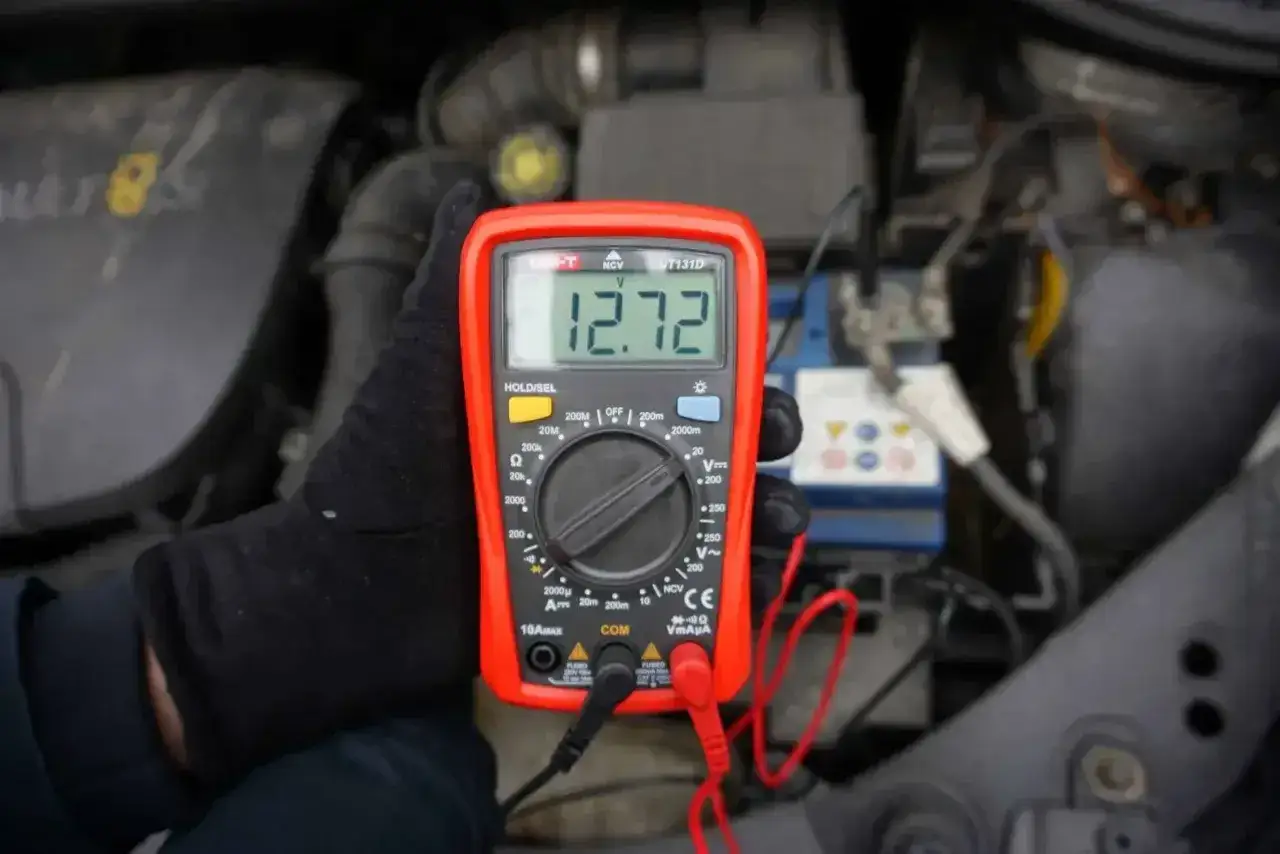 Pomiar napięcia akumulatora multimetrem pokazuje 12.72V. Sprawdzanie stanu technicznego pojazdu.