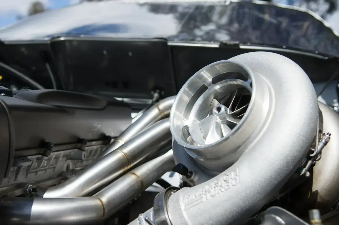 Błyszcząca turbosprężarka p0299 z polerowanymi kolektorami wydechowymi, gotowa do podkręcenia mocy silnika.