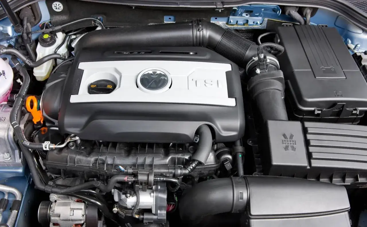 Silnik 1.8 TFSI z logo VW. Widoczna pokrywa zaworów, układ dolotowy i elementy osprzętu.