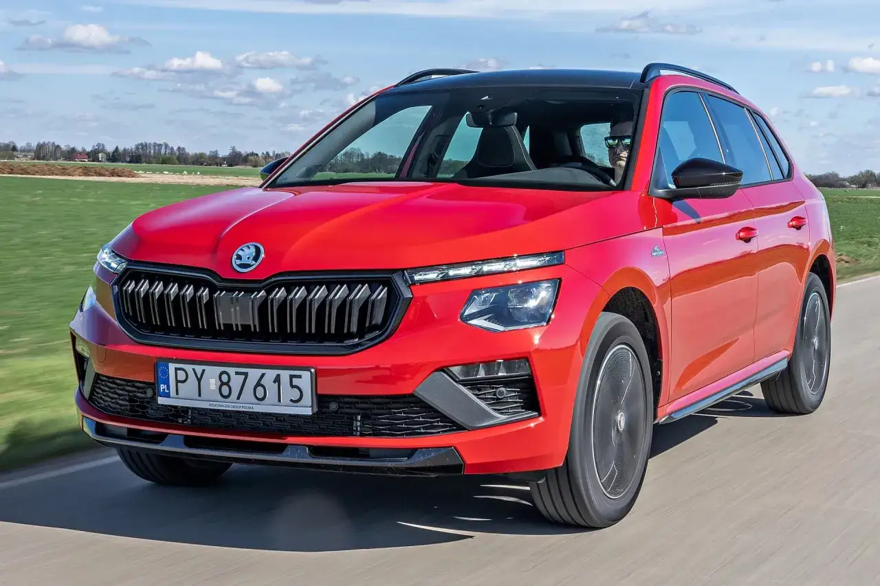 Czerwona Skoda Kamiq w ruchu, idealna na wakacyjne wyjazdy. Sprawdź atrakcyjną skoda kamiq cena i wybierz swój wymarzony model.