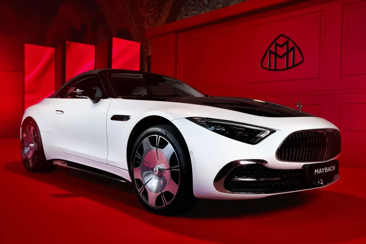 Elegancki biały Maybach z czarnym dachem, prezentowany na czerwonym tle. Poznaj jego wyjątkową maybach cena i luksus.