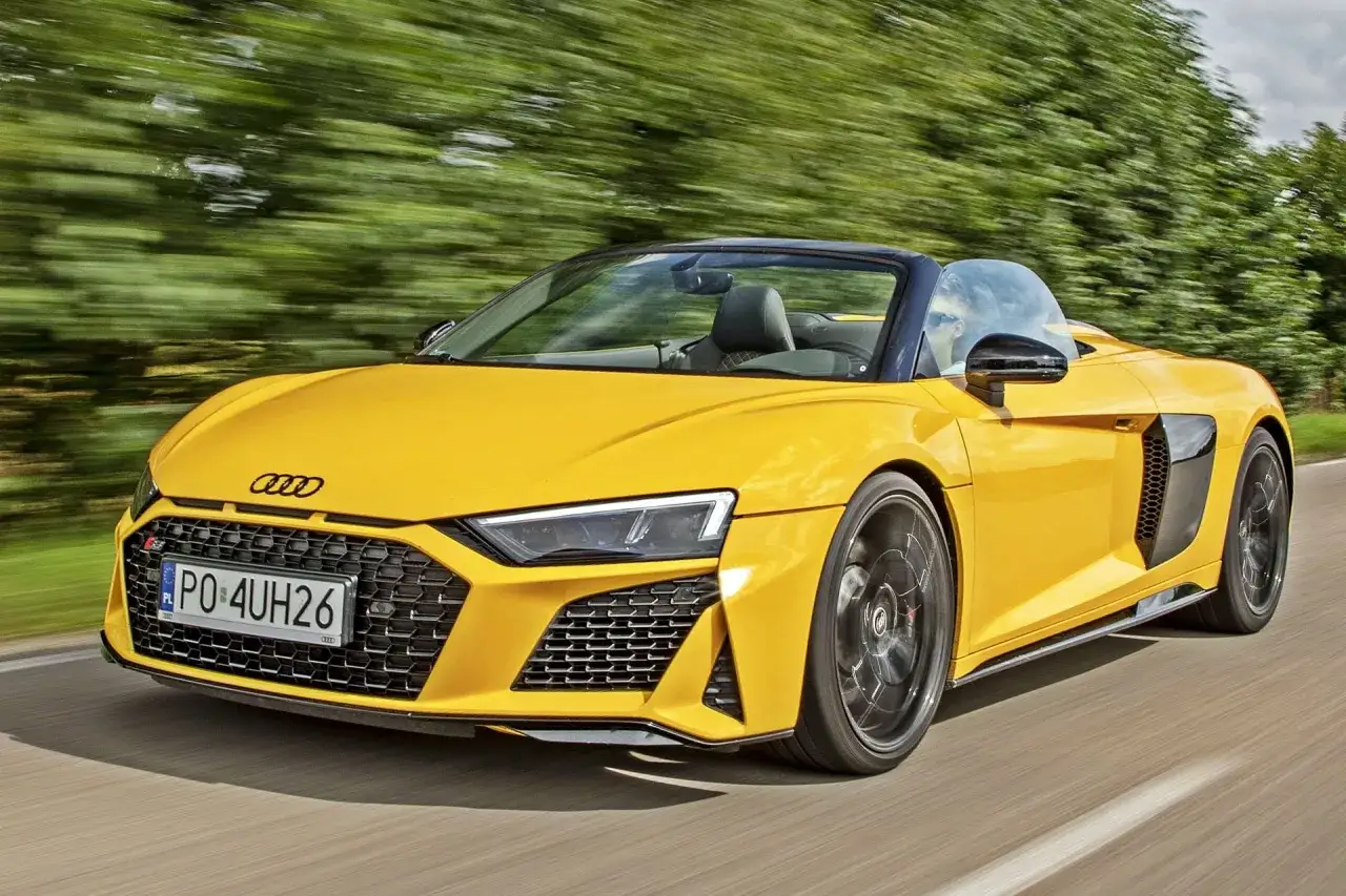 Żółty kabriolet Audi R8 pędzi po drodze. Sprawdź aktualną audi r8 cenę i poczuj moc!