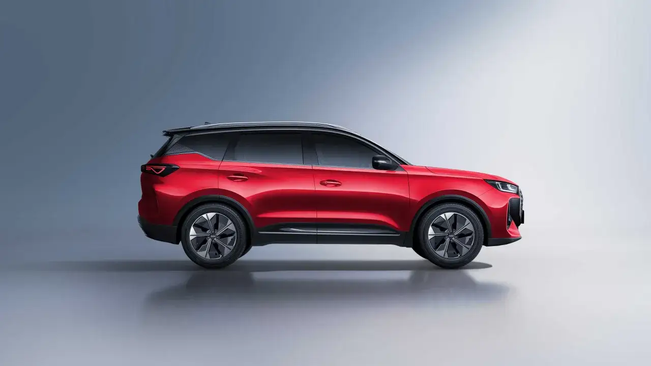 Czerwony samochód Chery SUV z czarnym dachem i przyciemnianymi szybami, prezentowany w studio.