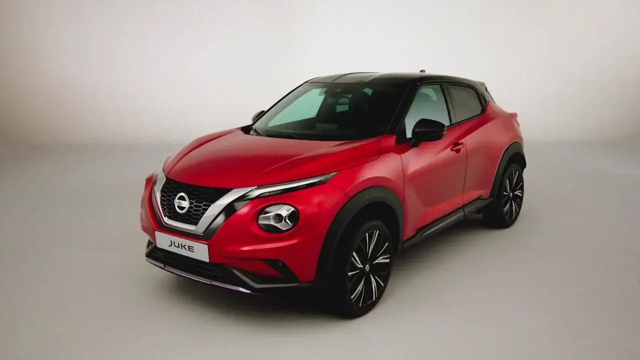 Czerwony Nissan Juke Nismo z czarnym dachem, sportowymi felgami i agresywnym przodem, gotowy do dynamicznej jazdy.