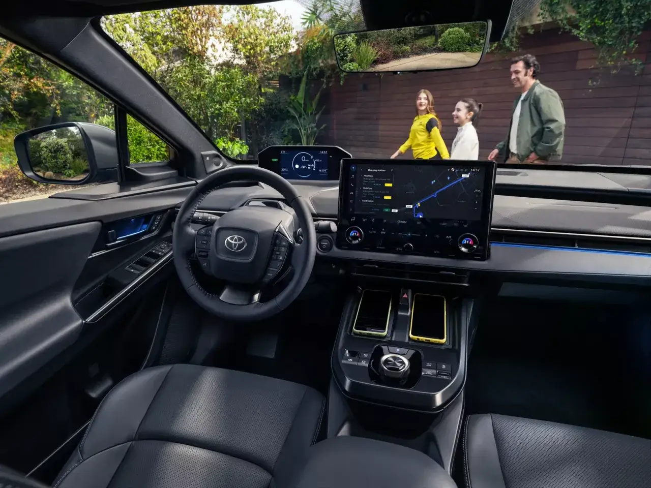 Wnętrze bz4x Toyota z ekranem nawigacji pokazującym stacje ładowania. Rodzina idzie obok.