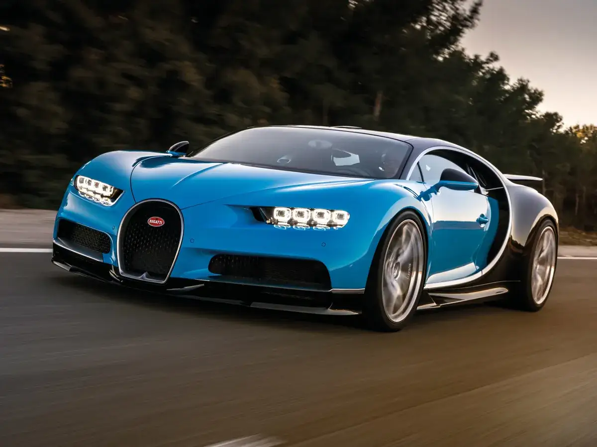 Niebieski Bugatti Chiron pędzi po drodze. Marzysz o takim aucie? Sprawdź, jaka jest bugatti cena!